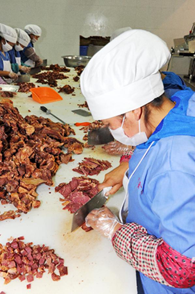西藏奇圣土特产品有限公司员工在加工牦牛肉(5月31日摄)