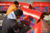 12月28日，西藏拉萨堆龙德庆区，古俗民族传统手工艺发展专业合作社员工在房屋上绘制藏式装饰。中新社记者 贡嘎来松　摄
