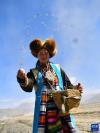 3月16日，村民在西藏日喀则市江孜县努康村参加春耕仪式时播撒种子。