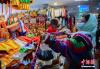 2月8日，西藏拉萨，民众在八廓商城选购年货香布（藏式建筑门窗上装饰的五彩布料）。